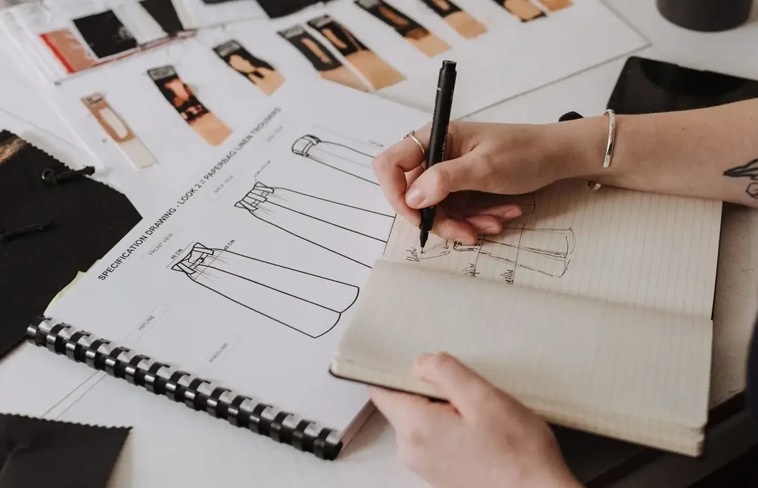 Garment sketches and fabric swatches laid out on a table