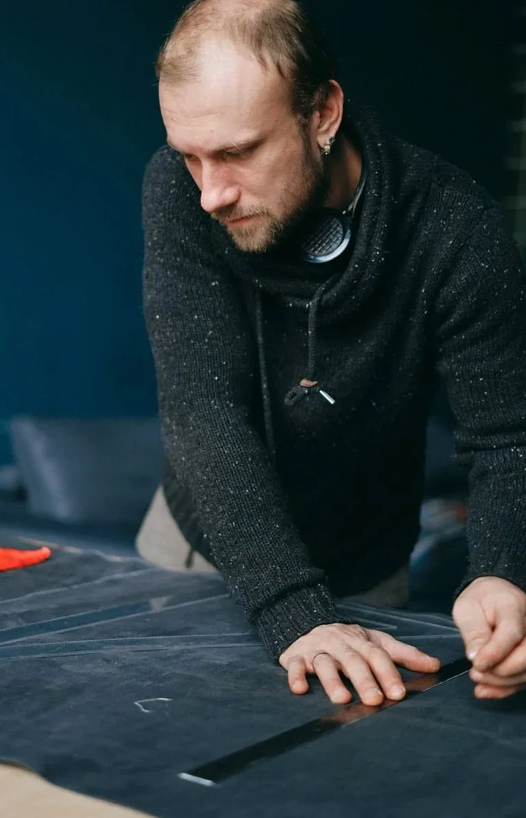 Dark fabric being measured and marked on a cutting table