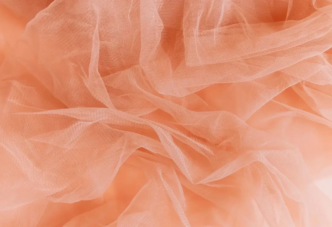 Soft peach tulle fabric in gentle folds