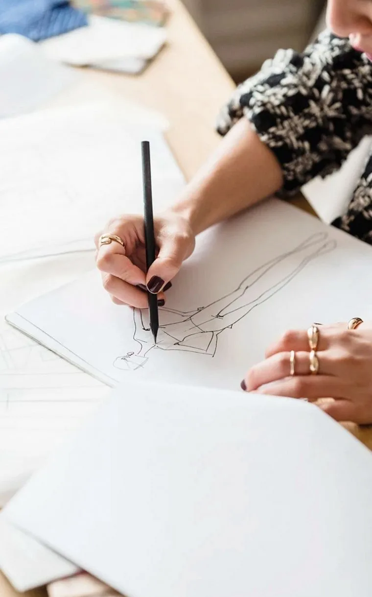 Hand sketching a garment design on paper