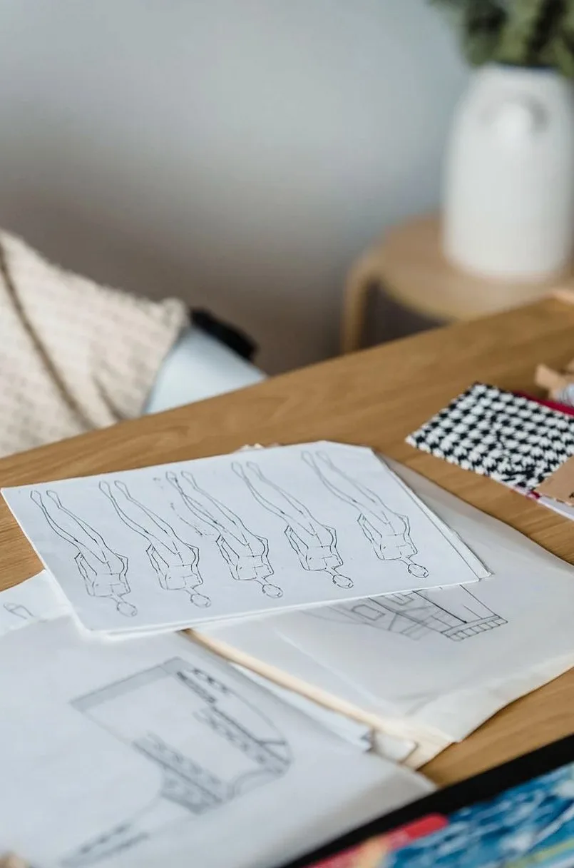 Pattern drawings and fabric swatches on a wooden desk